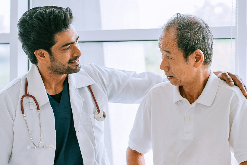 doctor comforts male patient with arm around shoulders